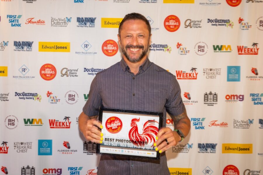 a man standing in front of a red carpet holding a box