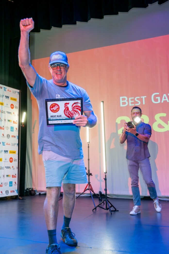 a man holding up a plaque on a stage