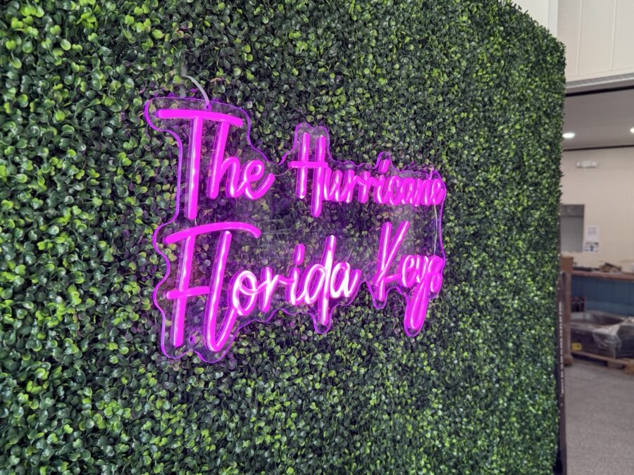 a green wall with a neon sign that says the hurricane florida key
