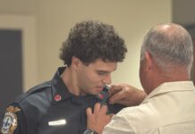a police officer helping a man fix his tie