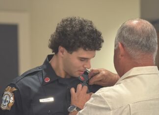 a police officer helping a man fix his tie