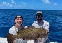 a couple of people on a boat with a fish