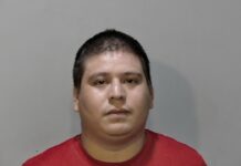 a man in a red shirt is looking at the camera