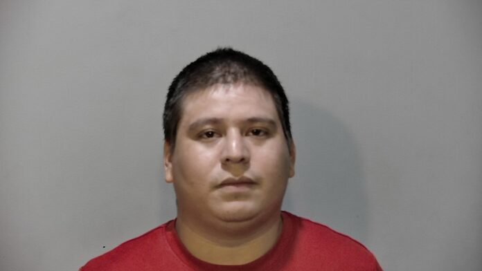 a man in a red shirt is looking at the camera