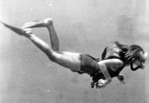 a black and white photo of a woman diving