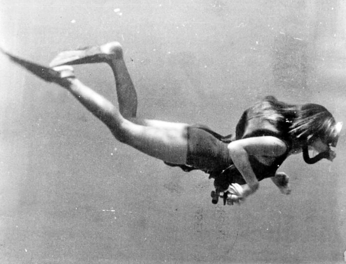 a black and white photo of a woman diving