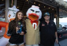 a couple of people standing next to a mascot