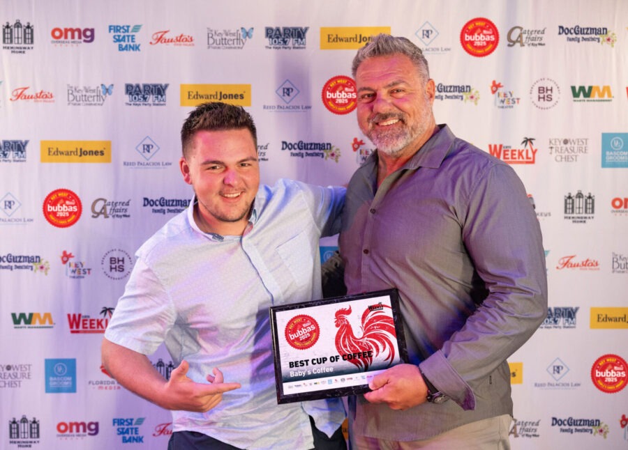 a couple of men standing next to each other on a red carpet