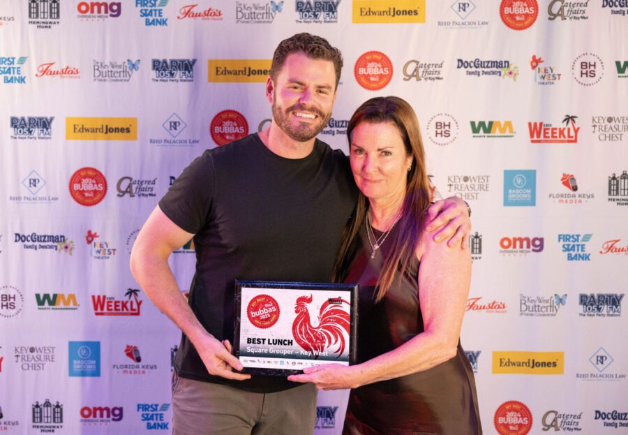 a man standing next to a woman on a red carpet