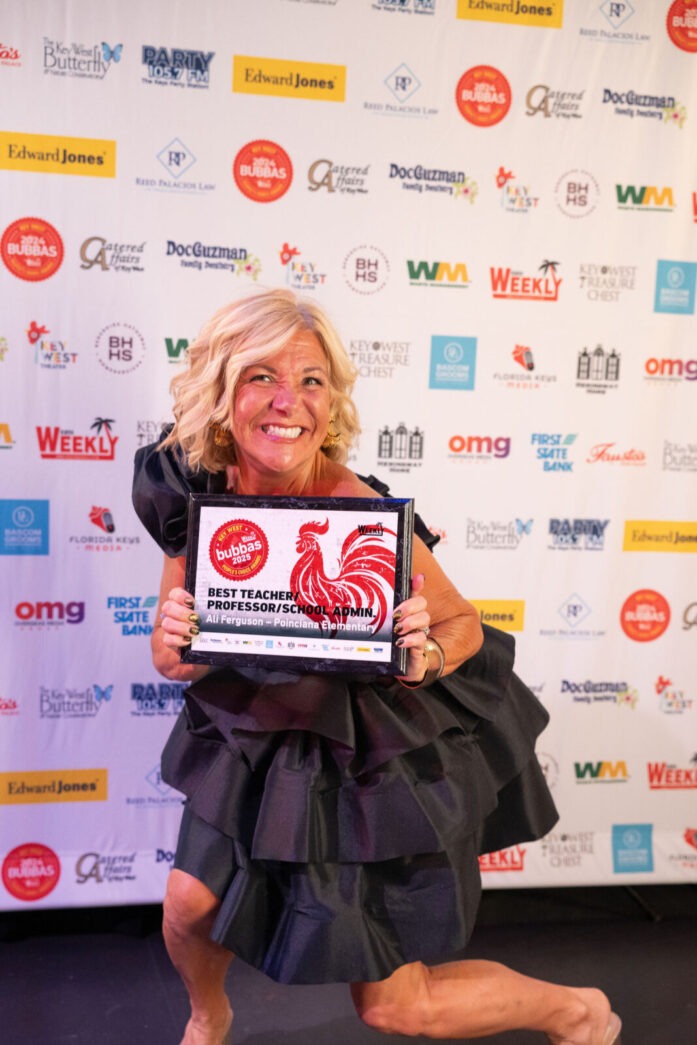 a woman in a black dress holding an award