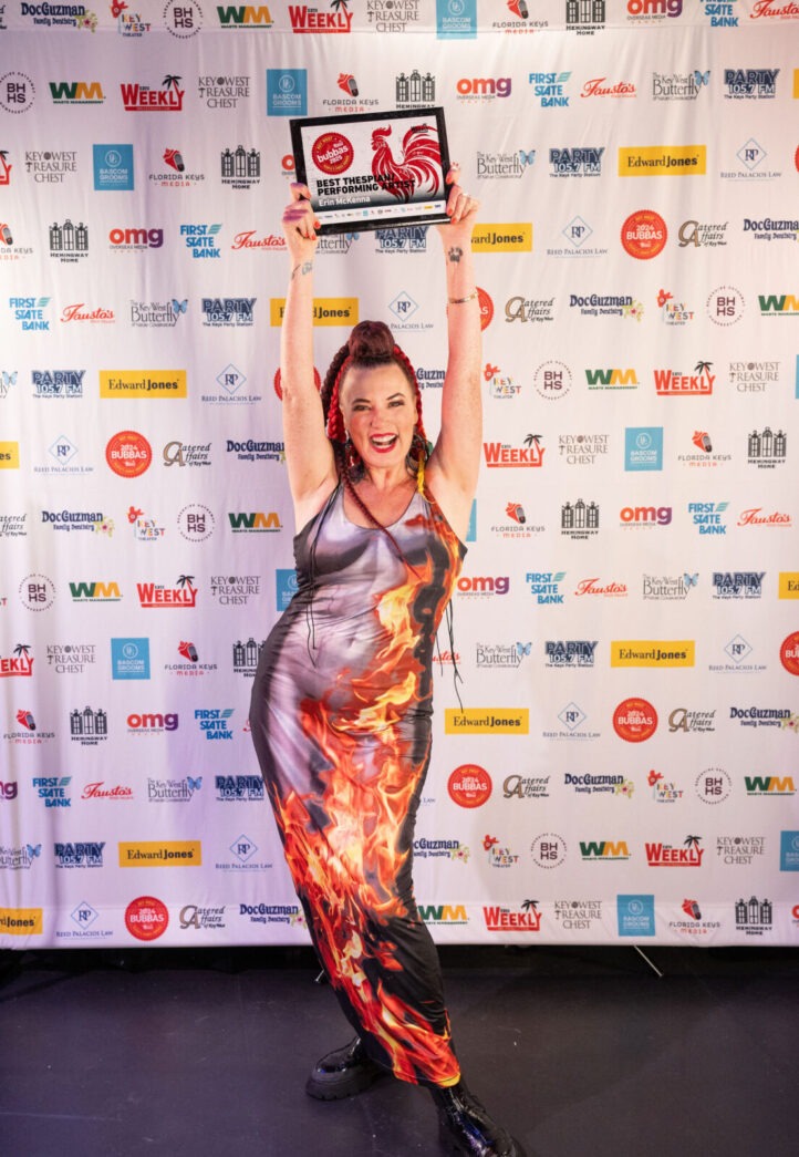 a woman in a dress holding up a plaque