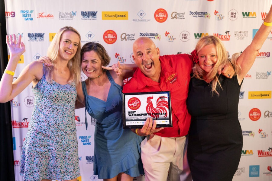 a group of people standing next to each other on a red carpet