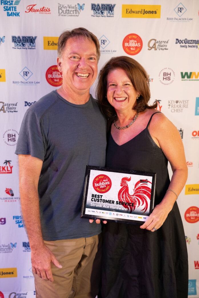 a man standing next to a woman on a red carpet