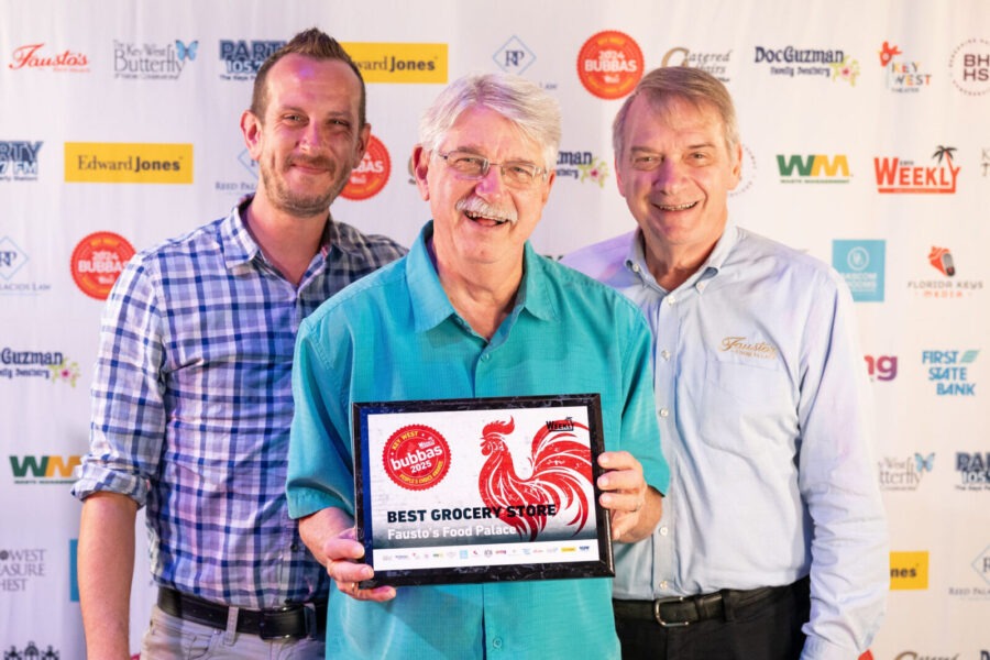 three men standing next to each other holding an award