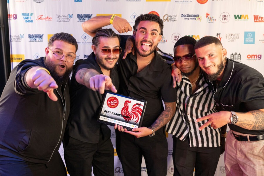 a group of men standing next to each other on a red carpet