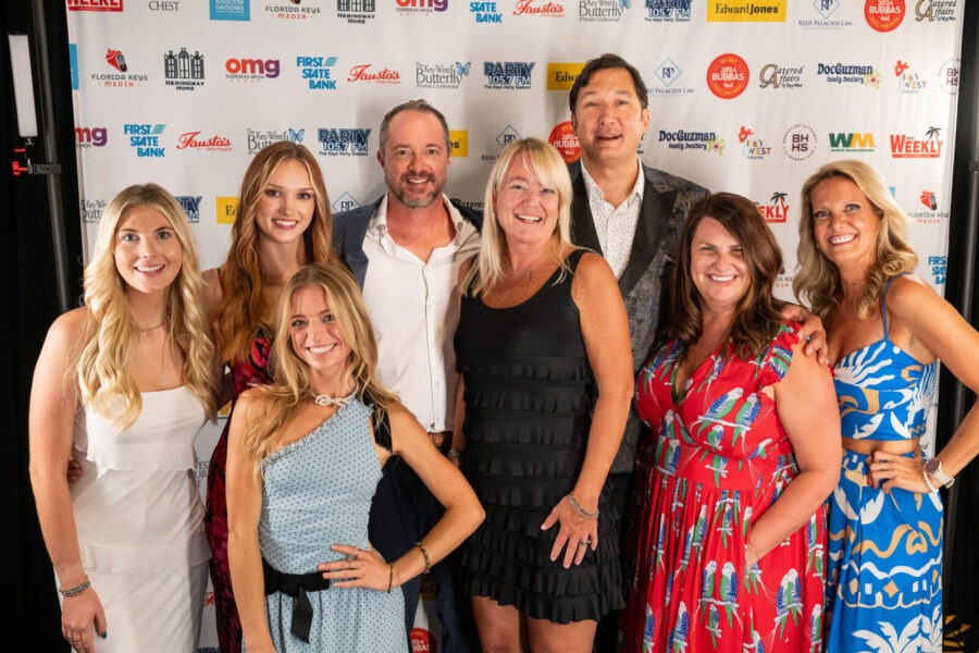 a group of people standing next to each other on a red carpet