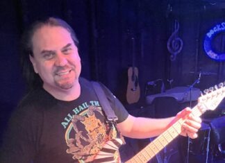 a man holding a guitar in front of a microphone