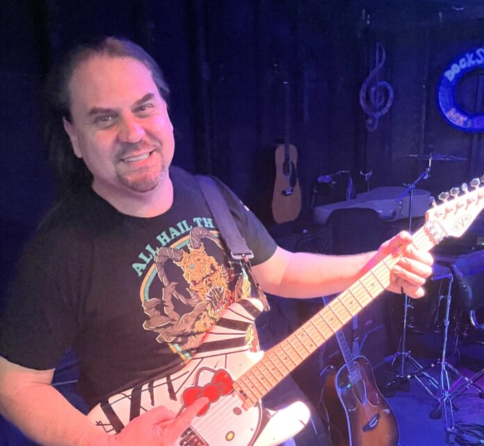 a man holding a guitar in front of a microphone