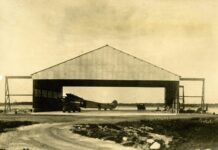 an old photo of an airplane in a hangar