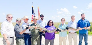 a group of people holding up a snake