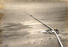 an aerial view of a railroad crossing over a body of water