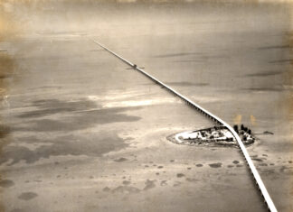 an aerial view of a railroad crossing over a body of water