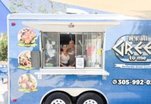 a woman and a man standing in the window of a food truck