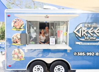 a woman and a man standing in the window of a food truck