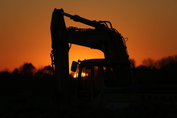 a tractor is silhouetted against the setting sun