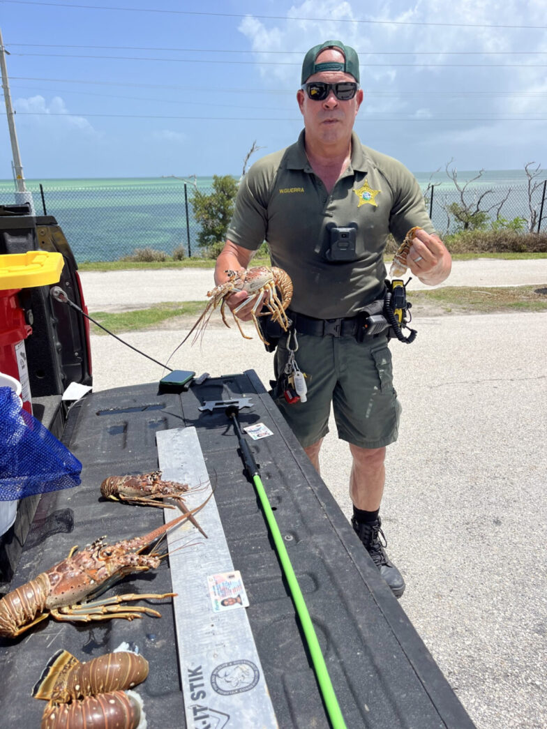 a man standing next to a truck with lobsters on it