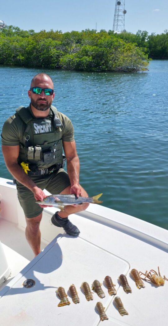 a man sitting on a boat holding a fish