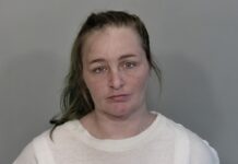 a woman in a white shirt is looking at the camera