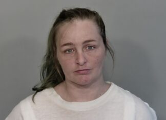 a woman in a white shirt is looking at the camera