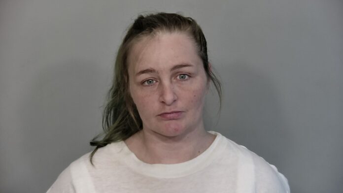 a woman in a white shirt is looking at the camera