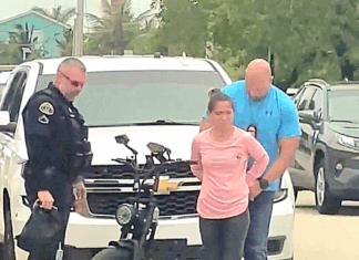 a woman standing next to a police officer next to a motorcycle