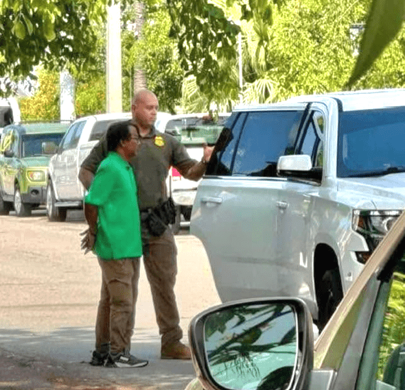a man and a woman standing next to a parked car