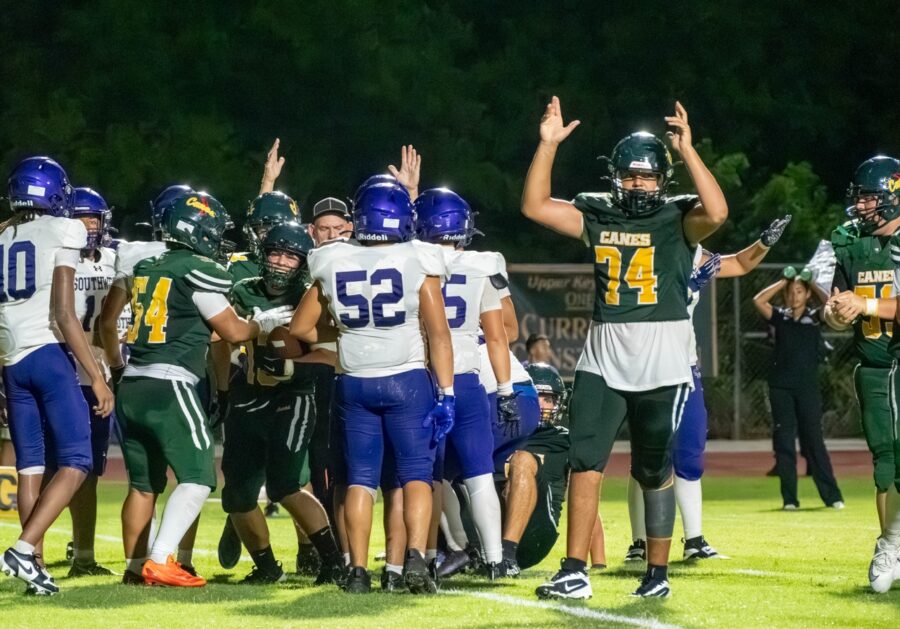 a group of football players standing on top of a field