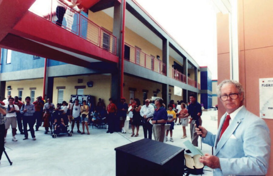 a man holding a microphone in front of a crowd of people
