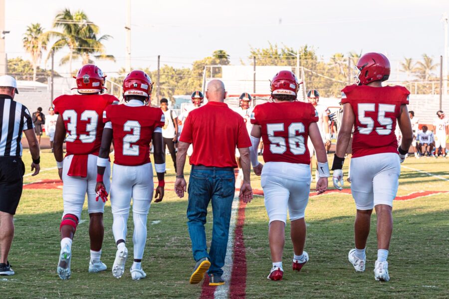 a group of football players walking across a field