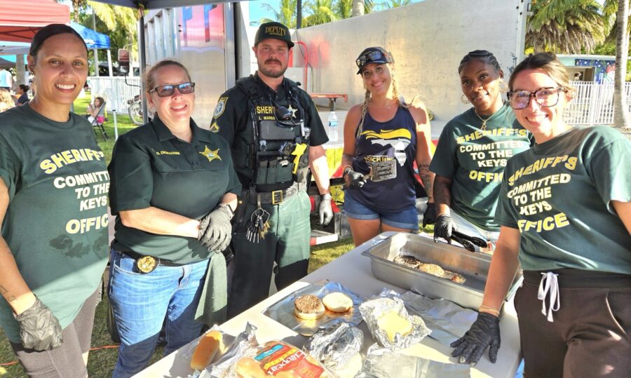 a group of people standing around a table with food on it