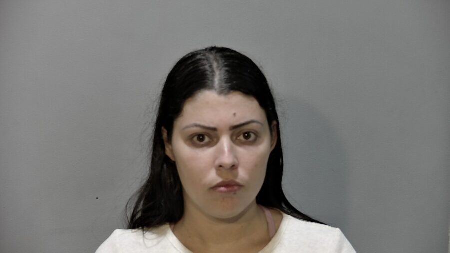a woman in a white shirt is looking at the camera