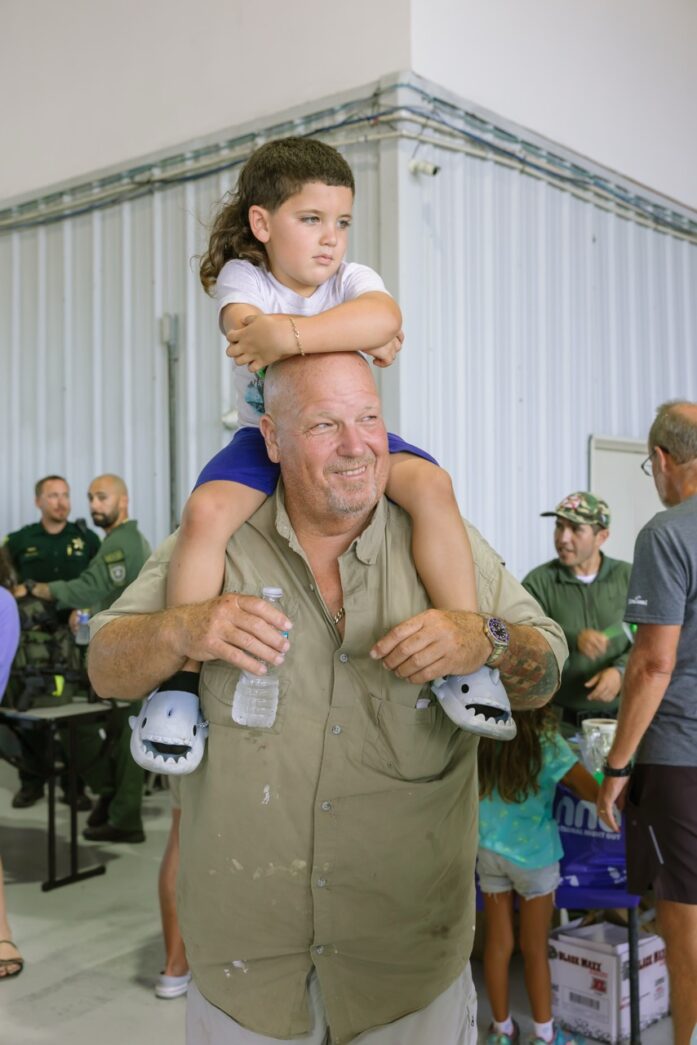 a man holding a little girl on his shoulders