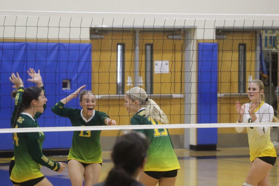 a group of young women playing a game of volleyball