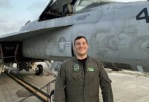 a man standing in front of a fighter jet