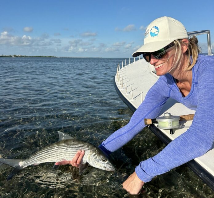 a woman holding a fish in the water
