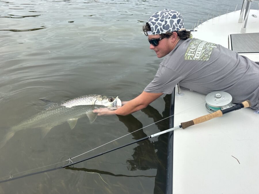 a man holding a fish on a boat