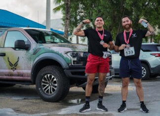 two men standing next to each other in front of a truck