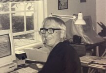 a man sitting at a desk with a computer in front of him