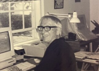 a man sitting at a desk with a computer in front of him