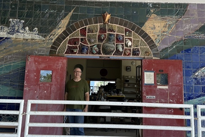 Dennis Loucks CFK Large a man standing in a doorway of a building